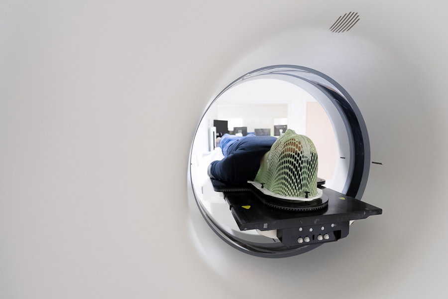 Dans le scanner, un masque thermoplastique assure l’immobilité du patient pour la précision de l’image. ©Nathanaël Mergui