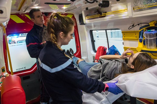 Une femme sur un brancard dans un camion de pompiers